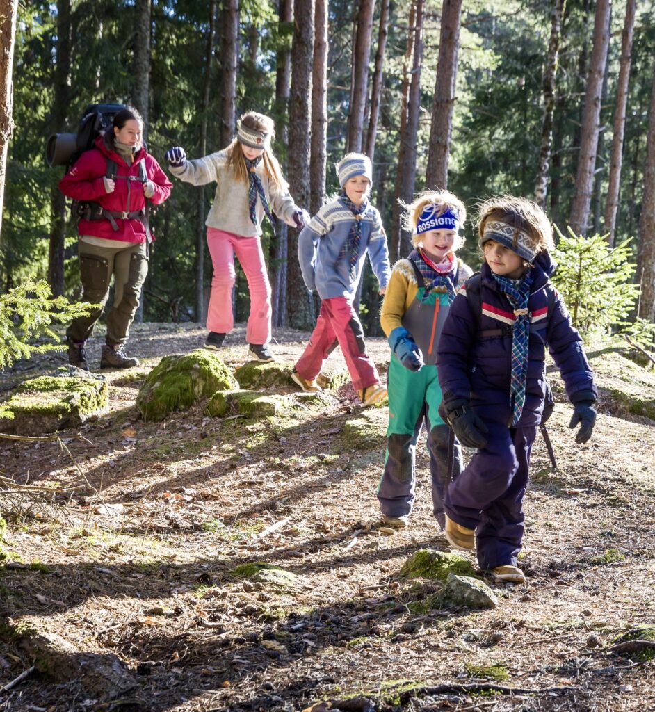 Speidere som går gjennom en solfylt skog